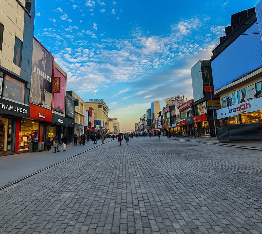 Modernized Saddar shopping district with sleek store facades, international and local brand outlets, wide pedestrian areas, and contemporary urban design