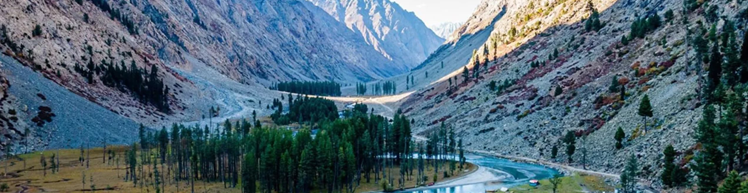 Green valleys, rivers, and forest-covered mountains of Khyber Pakhtunkhwa under a clear blue sky.