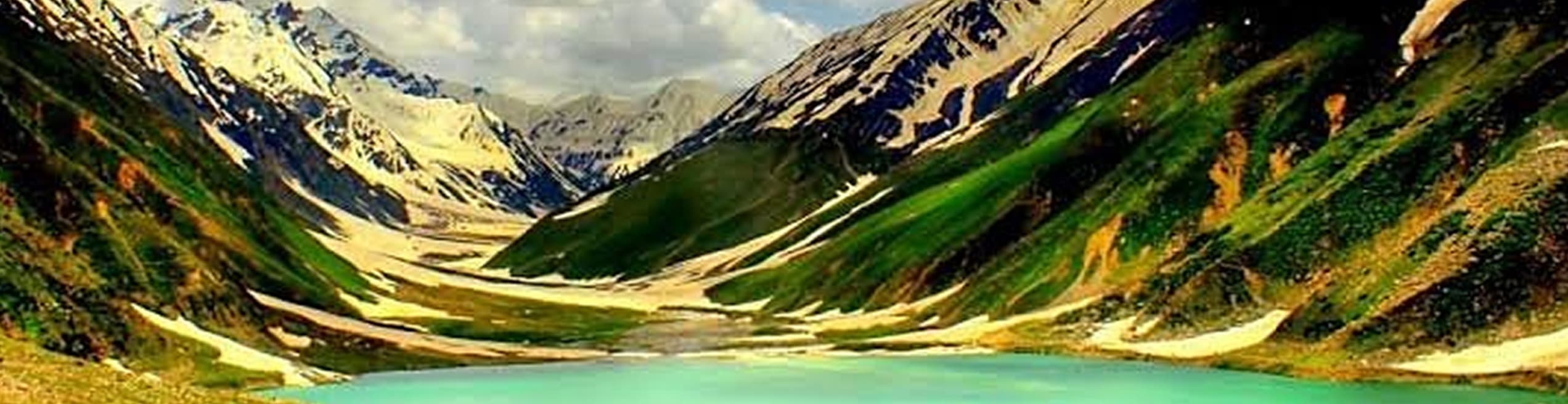 Naran Valley in KPK – green meadows, flowing river, and snow-covered mountains under a bright blue sky.