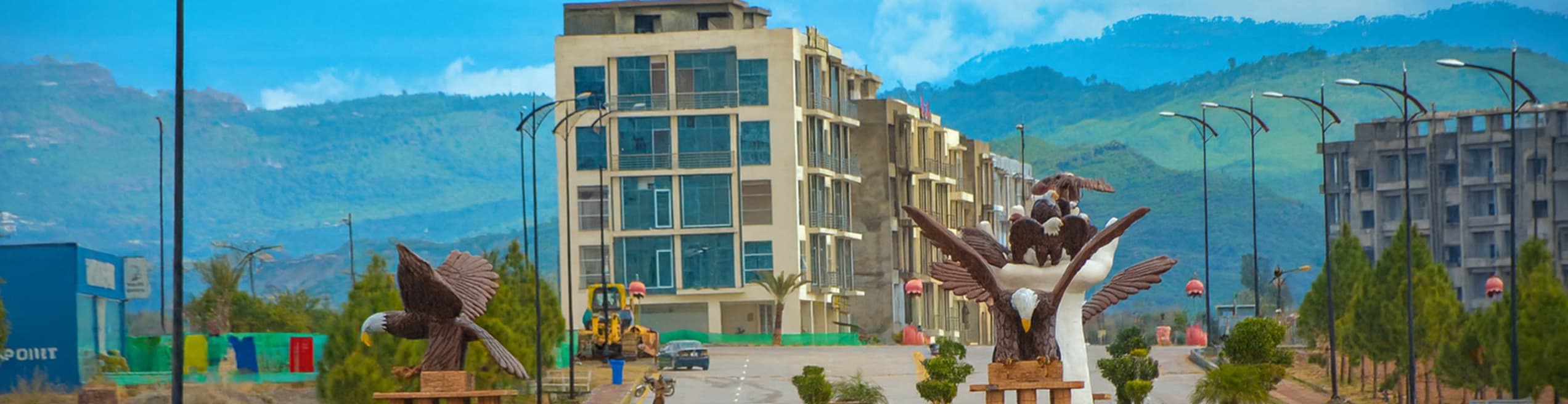  Impressive hawk statue monument at a major intersection in Bahria Enclave with lush green Margalla Hills visible in the scenic background