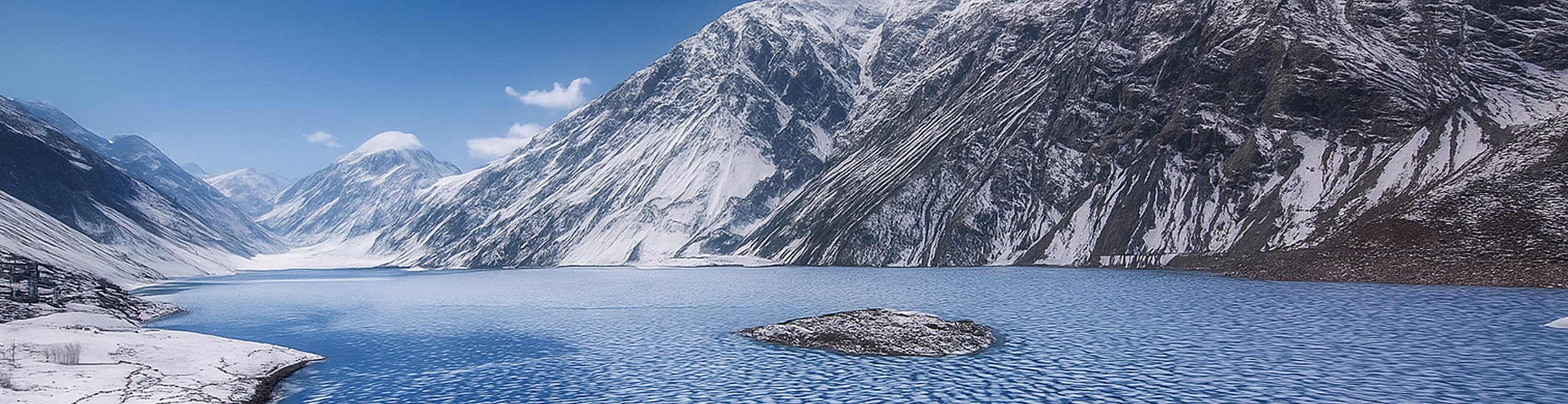 Sadpara Lake in winter surrounded by snow-covered mountain peaks in Skardu.