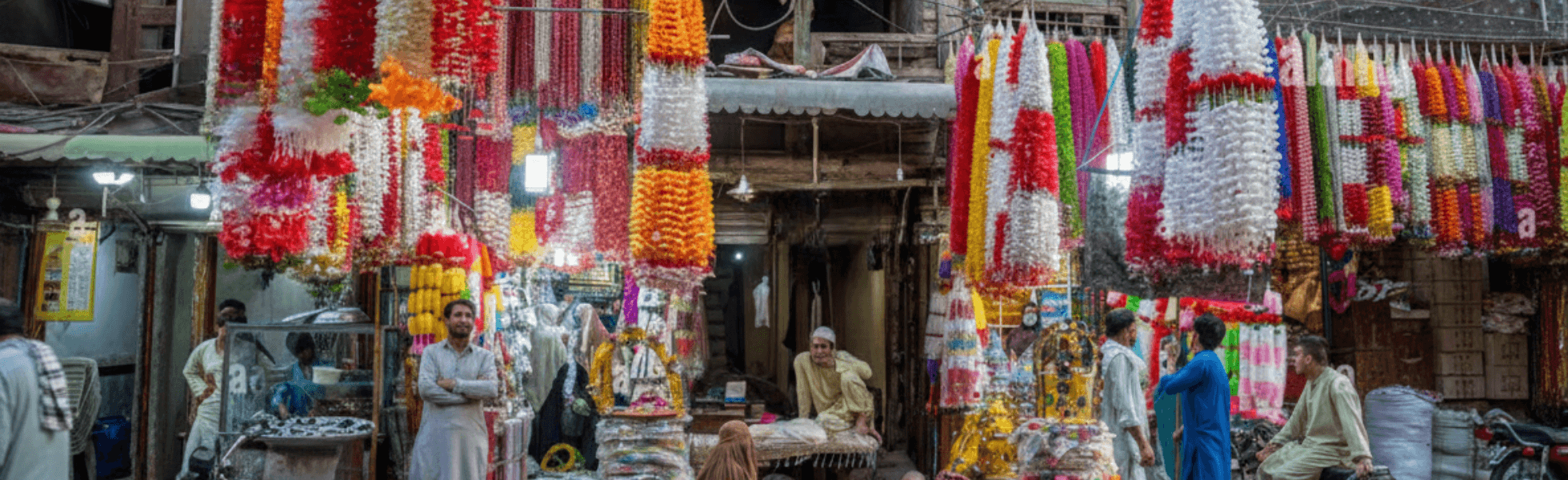 Wide banner view of bara market location showing long market lane and shop rows, Used shoes market Peshawar scene at Bara Market with bargain shopping and busy foot traffic