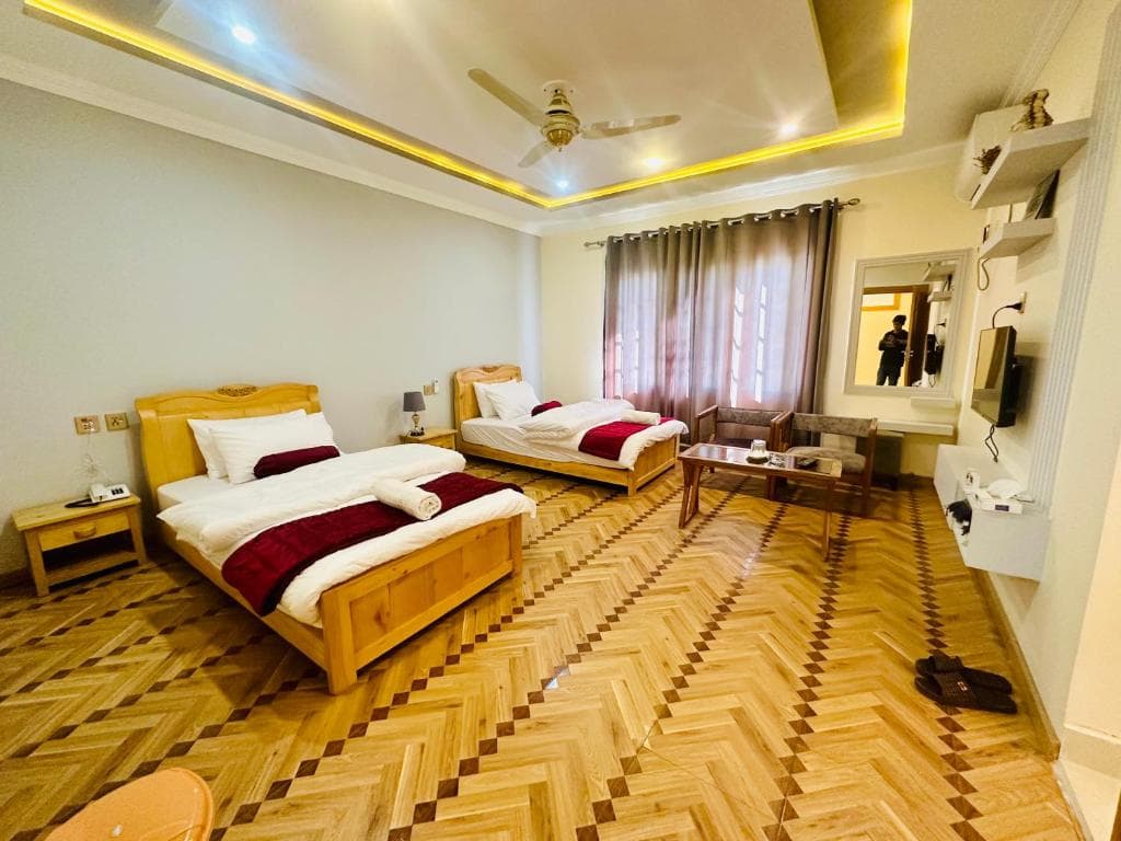Bedroom with one double bed and one single bed in Skardu hotel, Mountain view standard room at Areena Hotel