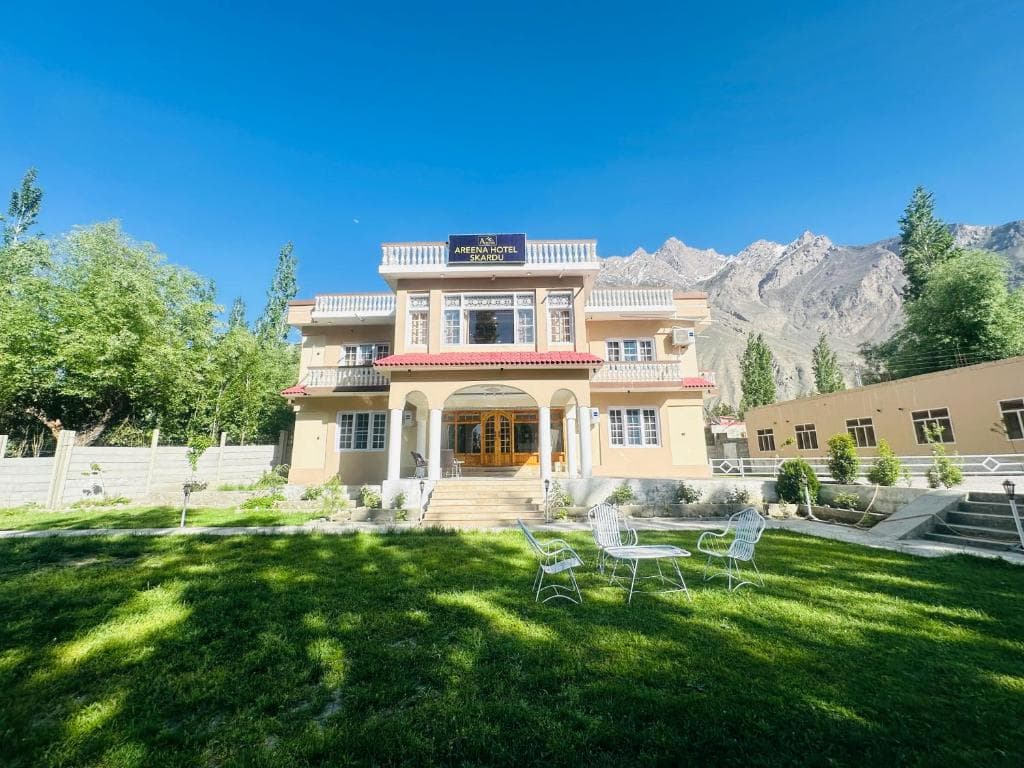 Hotel exterior with mountain backdrop in Skardu, Areena Hotel surrounded by trees and landscape