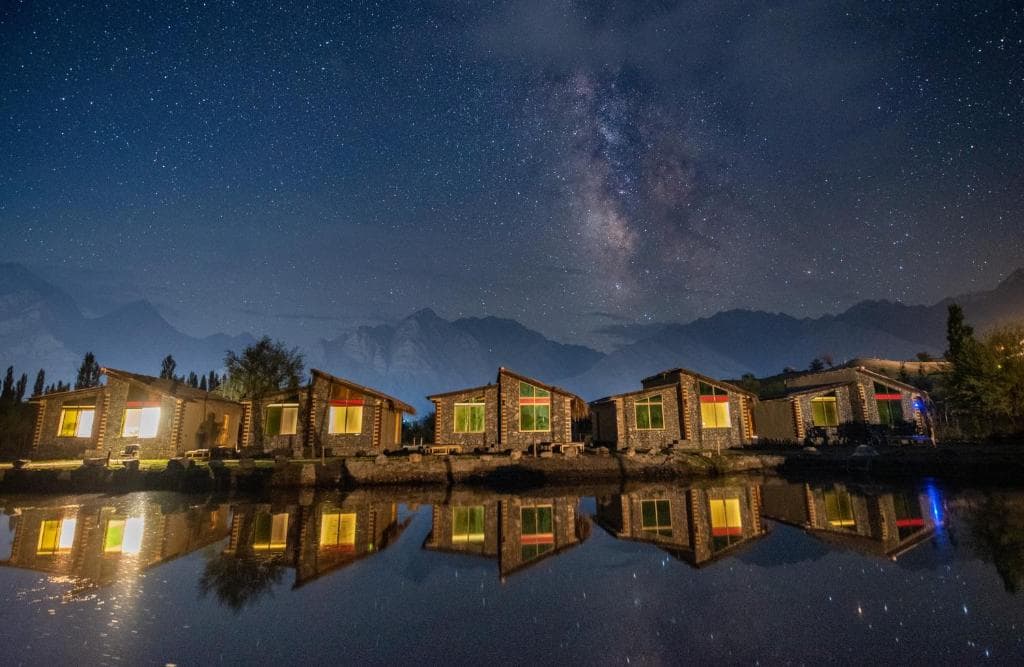 Hotel exterior at night in Skardu with mountain backdrop, Luxury hotel night view near lake in Katpana