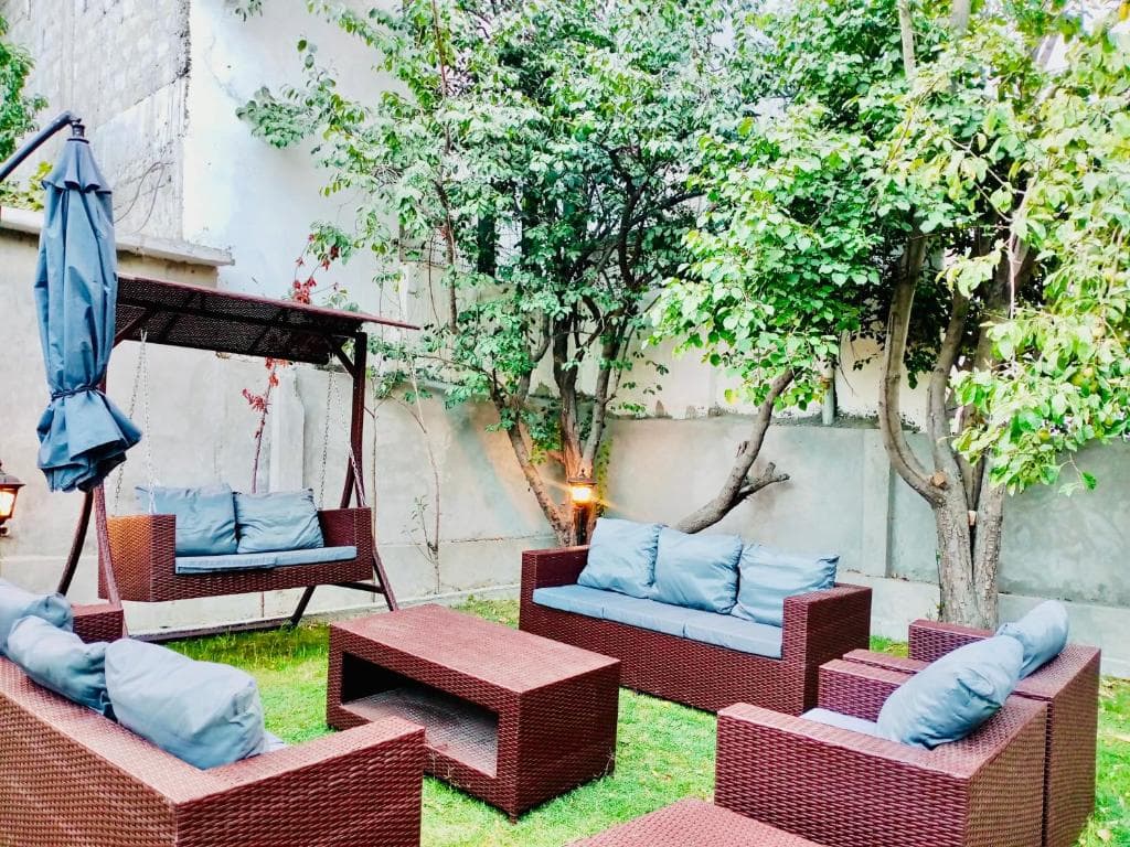 Garden lawn with trees and seating in Skardu, Outdoor relaxation space at Shah Hujra
