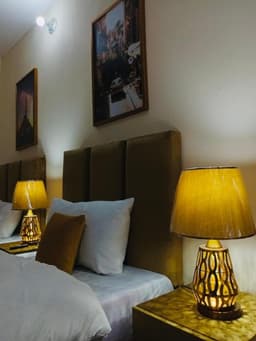 Close up of bed with bedside lamps in Skardu room, Cozy deluxe room setup at Shah Hujra