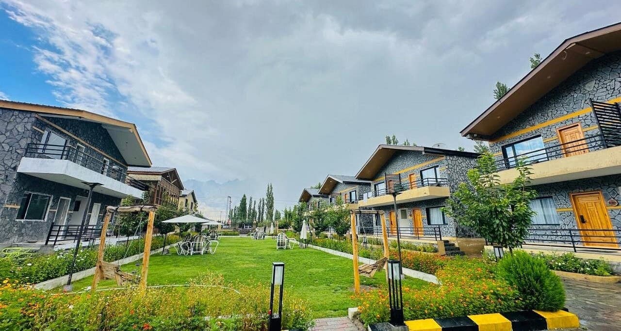 Large lawn with chairs tables and swings in Skardu hotel, Outdoor relaxation area at Qayam Skardu