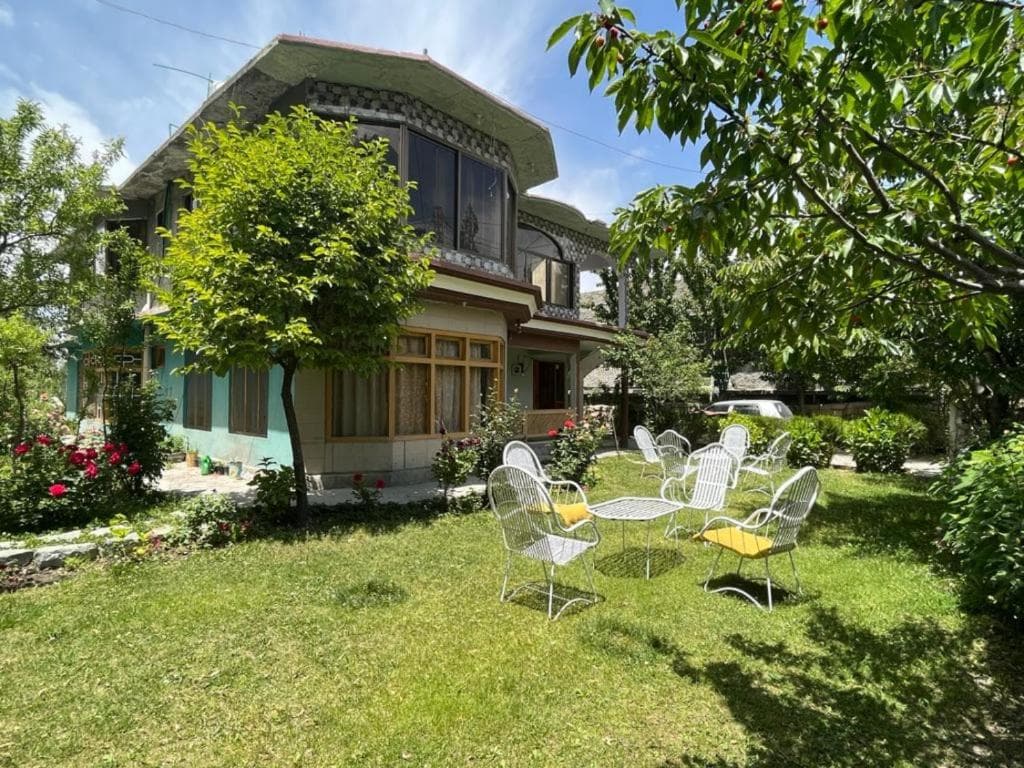 Exterior facade of Flora Inn Skardu with mountain surroundings, hotel building in Hassan Colony Skardu