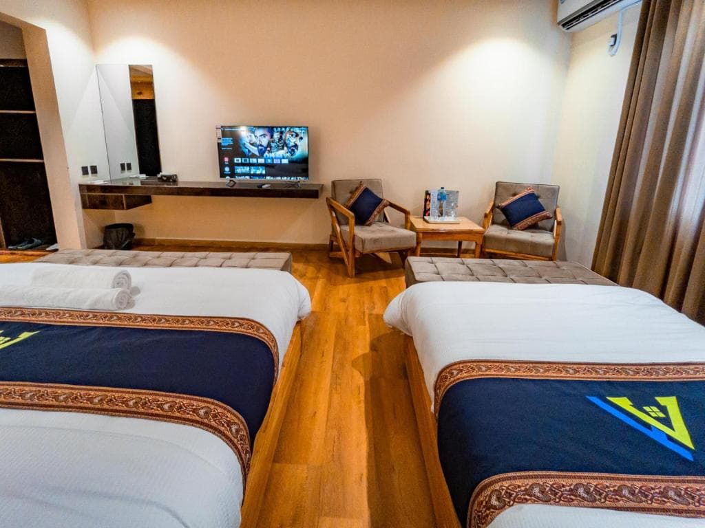 Seating area and television inside deluxe triple room Skardu, Apex Hotels and Resorts room interior