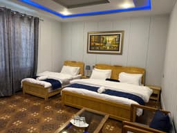 Family room bedroom with double bed and single bed at Areena Hotel Skardu Family room with double bed and single bed in Skardu, Areena Hotel Skardu bedroom with air conditioning