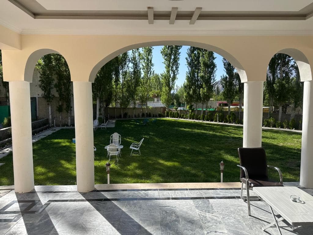 Green lawn seating area at Areena Hotel Skardu Green lawn with white plastic chairs at Areena Hotel Skardu, Outdoor garden seating in Skardu hotel